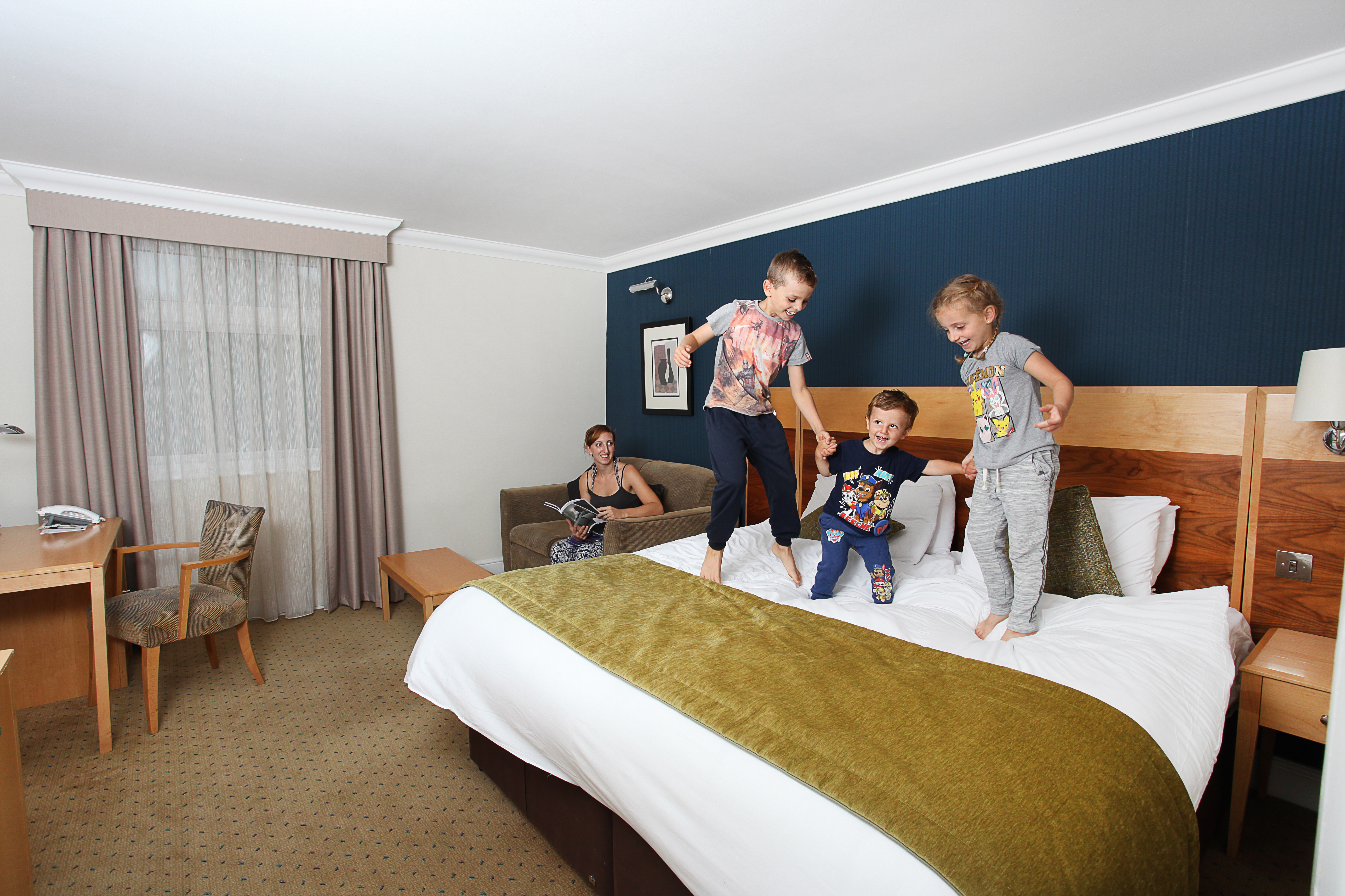 Children jumping happily on a hotel bed